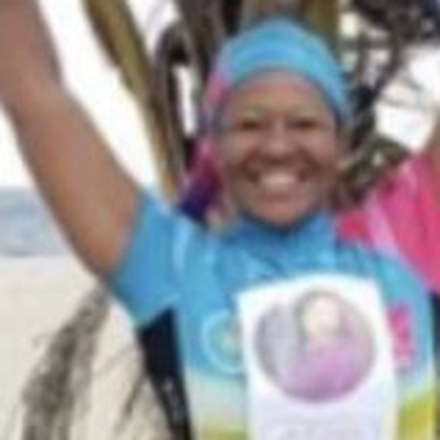Jasmine Waggner at the end of a charity ride, holding her bicycle above her head